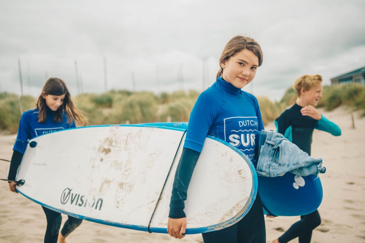 kinderen met wetsuit en surfboard