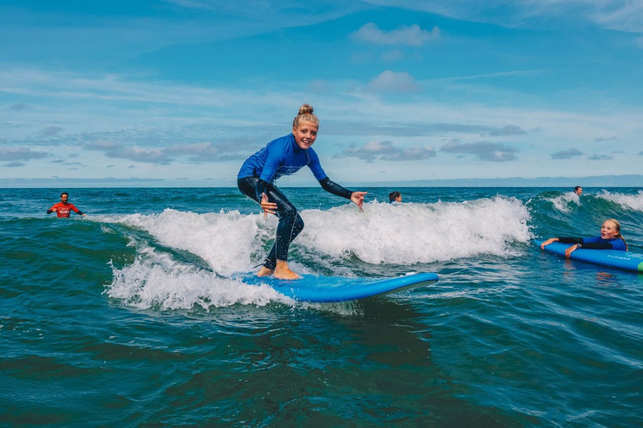 meisje surft tijdens surfkamp